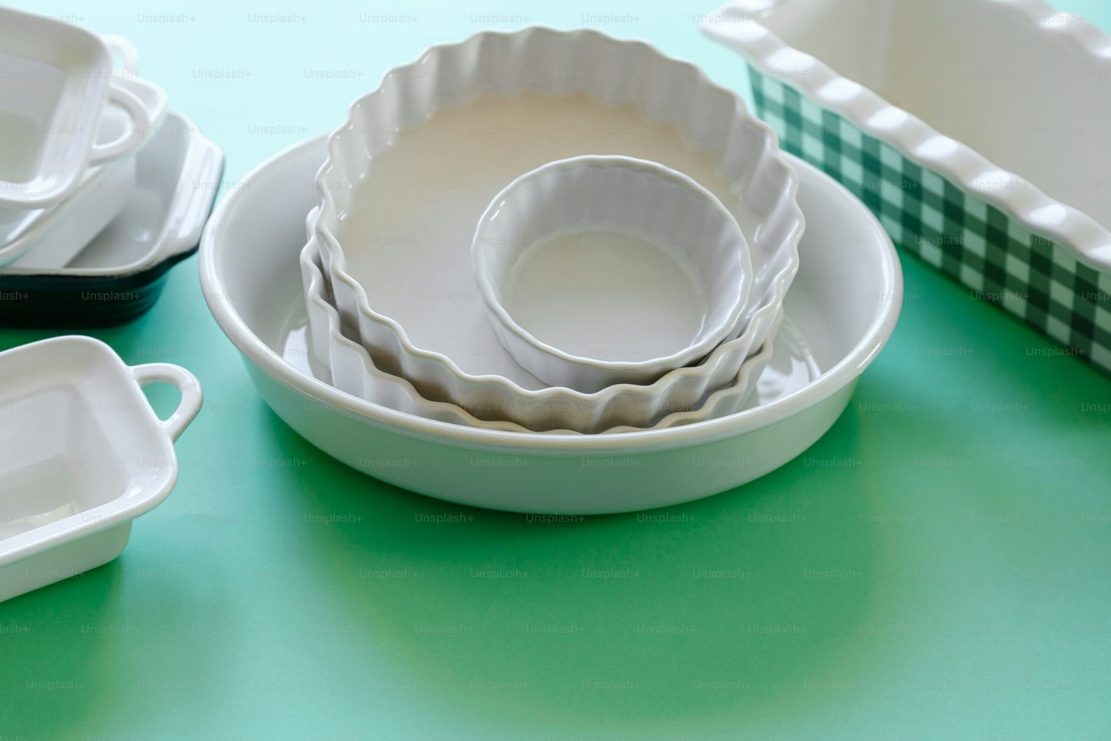 a green table topped with white dishes and dishes scaled